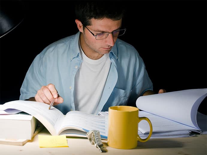 Photo of man with glasses studying