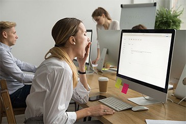 Photo of woman yawning at work